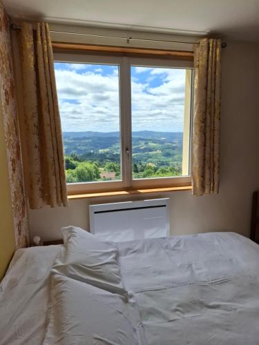 a bed in a bedroom with a large window at Passiflore in Saint-Racho
