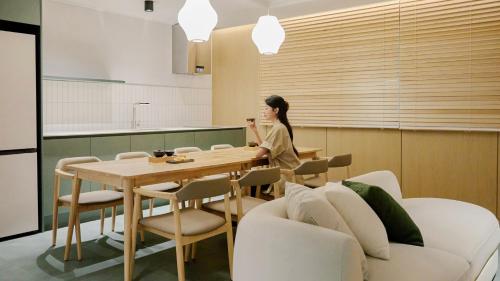 a woman sitting at a table in a kitchen at Anook Hotel Busan Gwangalli in Busan
