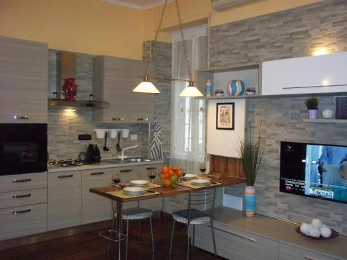 a kitchen with a table with chairs and a tv at Il Sole di Ostia in Lido di Ostia