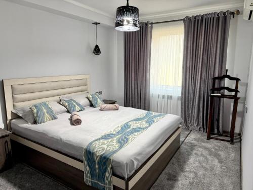 a bedroom with a bed with a stuffed animal laying on it at Joy Fergana Guesthouse in Fergana