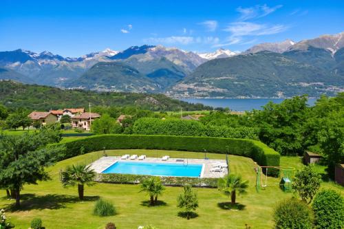 an estate with a swimming pool and mountains at Iris in Colico