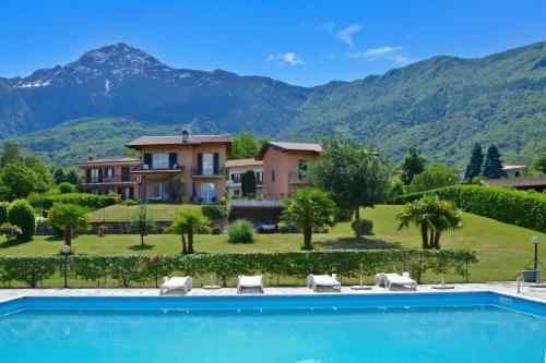 a villa with a swimming pool and mountains in the background at Iris in Colico