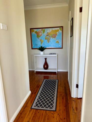 a floor mat in a hallway with a map on the wall at Ronelle Cottage in Berrima