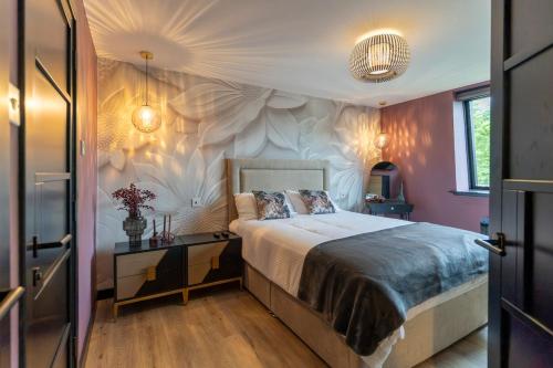 a bedroom with a bed with a flower wall at Gleneagles Village Penthouse in Tullibardine Station