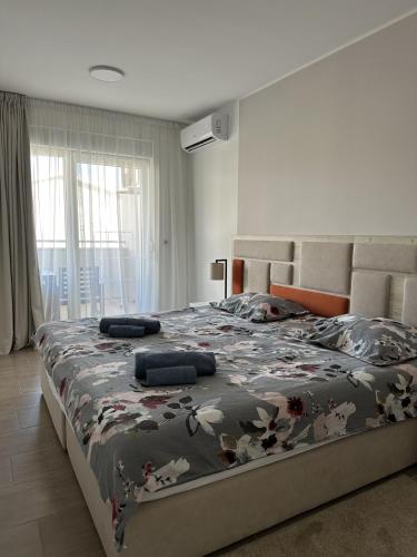 a bedroom with a large bed with a floral blanket at Aurum Apartmanı in Vodice