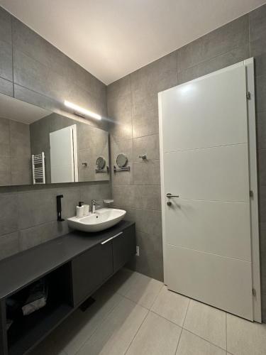 a bathroom with a sink and a shower with a mirror at Aurum Apartmanı in Vodice
