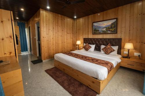 a bedroom with a large bed with wooden walls at Hotel The Nature Heaven, Mussoorie - Affordable Luxury Stay in Mussoorie with Mountain View in Mussoorie