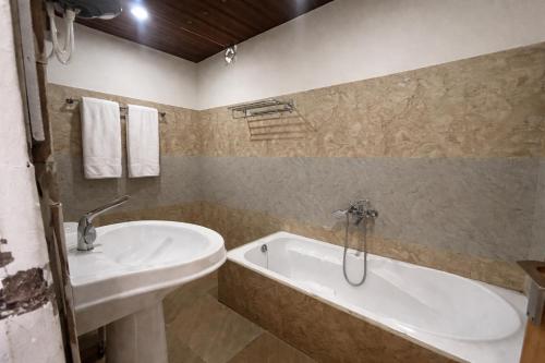 a bathroom with a tub and a sink and a bath tub at Hotel The Nature Heaven, Mussoorie - Affordable Luxury Stay in Mussoorie with Mountain View in Mussoorie