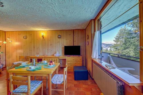 a dining room with a table and a television at Appartamento Bareu Mountain View - Happy Rentals in Sauze dʼOulx