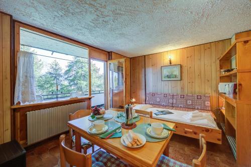 a dining room with a table and a window at Appartamento Bareu Mountain View - Happy Rentals in Sauze dʼOulx