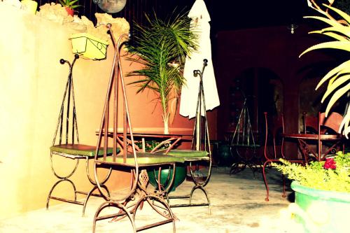 a table and chairs in a room with plants at Riad Le Lieu in Tiznit