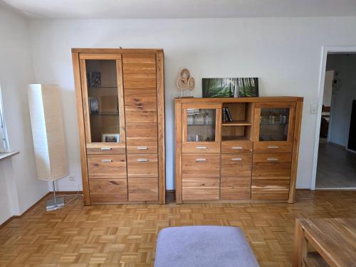 a living room with wooden cabinets and a table at Seehaus Brigitte in Owingen