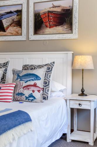 a bedroom with a bed and a table with a lamp at Admirals Lodge Guest House and Brightways self catering apartments in Port Elizabeth