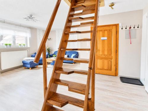 a wooden spiral staircase in a living room with blue chairs at Seehund in Neuharlingersiel