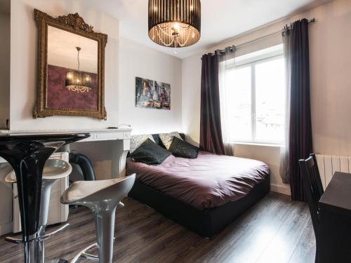 um pequeno quarto com uma cama e uma janela em Dormir A Lyon - Cosy Saxe-Gambetta em Lyon