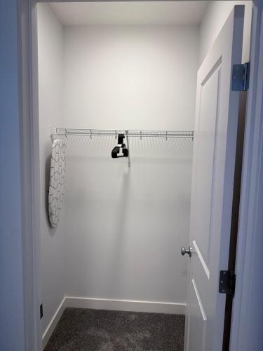 a bathroom with a white wall and a white door at A very cozy 2-bedroom apartment in Calgary