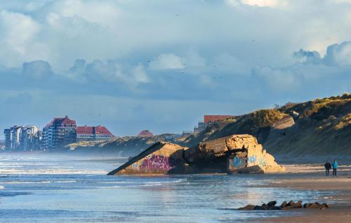 a group of people standing on a beach near the ocean at Jolie Maison Avec Cour in Grand-Fort-Philippe