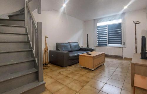 a living room with a leather chair and stairs at Jolie Maison Avec Cour in Grand-Fort-Philippe