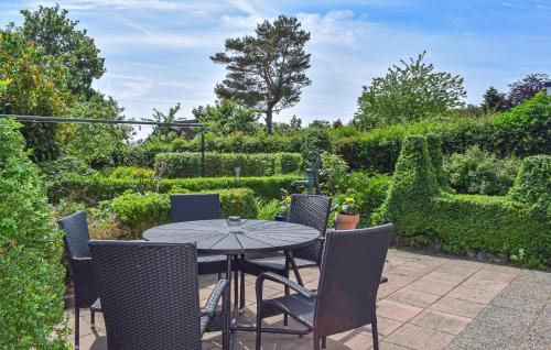 a patio with a table and chairs in a garden at 3 Bedroom Pet Friendly Home In Löderup in Löderup