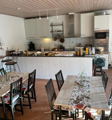 a kitchen with tables and chairs and a kitchen with a counter at skummeslöv B & B in Laholm