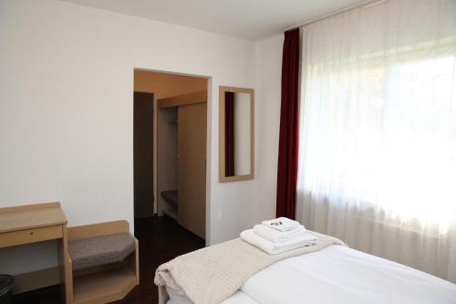 a bedroom with a white bed and a window at Hotel Garni Alte Post in Schallbach