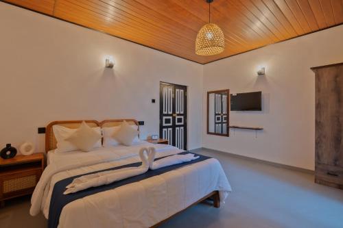 a bedroom with a large bed with a wooden ceiling at Heritage Villa - 05 Bedroom Family Villa in Central Ahangama in Ahangama