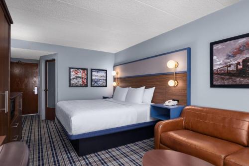 a hotel room with a bed and a couch at AmericInn by Wyndham Madison West in Madison