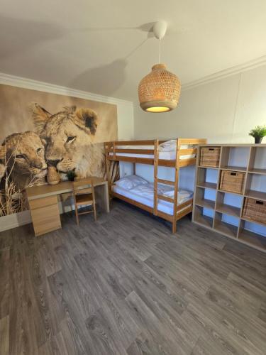 a room with two bunk beds and a mural of a lion at Ferienhaus Löwe in Niedenstein