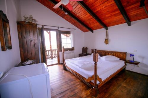 ein Schlafzimmer mit Bett und Deckenventilator in der Unterkunft Casa Pescareasca - Complex Plaja Golf in Corbu