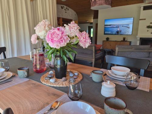 a table with a vase of pink flowers on it at Partsi Veski in Partsi