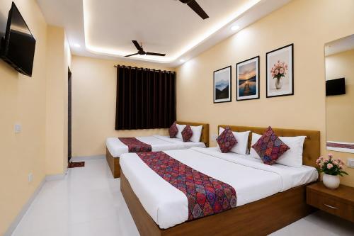 a hotel room with two beds and a television at Hotel Philips in Kolkata