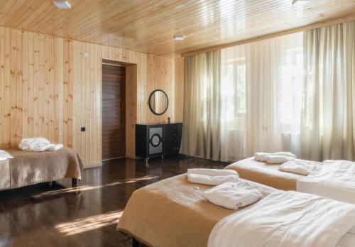 a room with two beds and a television in it at Green House -მწვანე სახლი in Tsalka