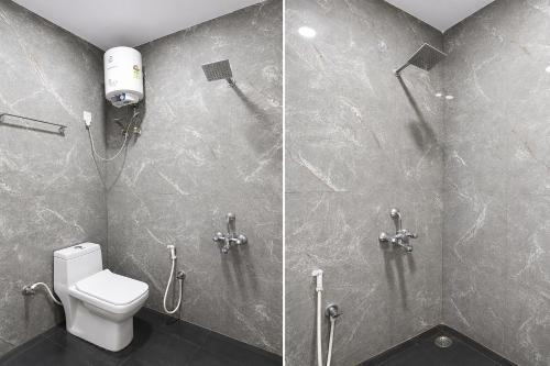 a bathroom with a toilet and a glass shower stall at Hotel Philips in Kolkata