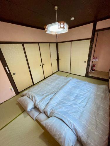 a large bed in a room with cabinets at サニーサイドホステル2号館 in Uji
