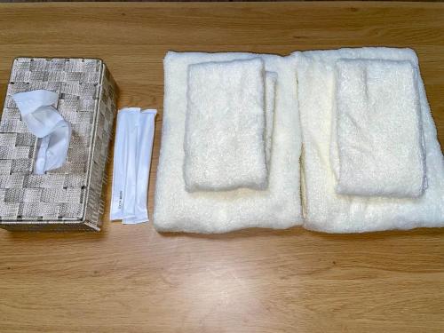 a towel and a basket on a wooden floor at サニーサイドホステル2号館 in Uji