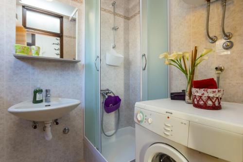 a bathroom with a sink and a washing machine at Guesthouse Ivona in Dubrovnik