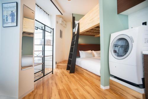 a bedroom with a bed and a washing machine at ORI Ikebukuro in Tokyo
