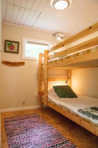 a bedroom with two bunk beds and a rug at Pensionat Lövängen, Ljugarn in Ljugarn