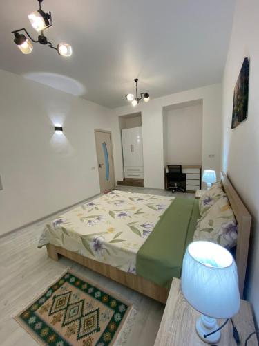 a bedroom with a bed and a table and a lamp at Green Home on Mtatsminda in Tbilisi City