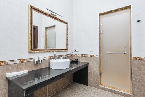 a bathroom with a sink and a mirror at Ichan Qal'a Premium Class Hotel in Tashkent