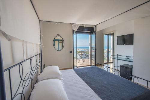 a bedroom with a bed and a view of the ocean at Sympathy Hotel in Martinsicuro