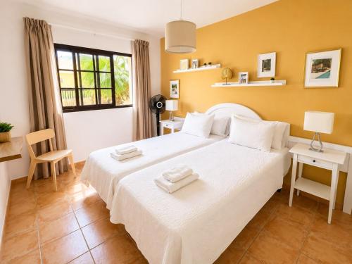 a bedroom with a large white bed and a window at Holiday in Playa Calera - Swimming pool in Valle Gran Rey