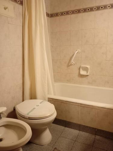 a bathroom with a toilet and a sink and a tub at Hotel Rivoli in Mar del Plata