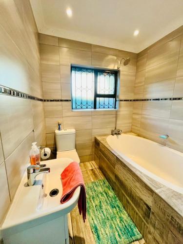 a bathroom with a sink and a bath tub at Emangwaneni Guest House in Kloof