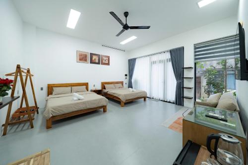 a bedroom with two beds and a tv in it at Dreams Boutique House in Hue City Center in Hue