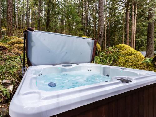 eine Badewanne mitten im Wald in der Unterkunft ArborMyst in Glacier