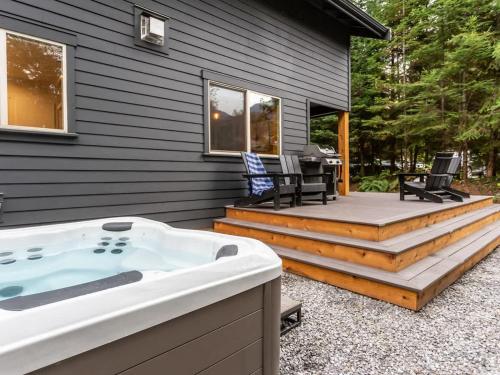 a hot tub on a deck next to a house at Wandering Rivers Retreat in Glacier