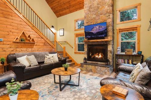 a living room with couches and a fireplace at Cottonwood Cabin in Glacier