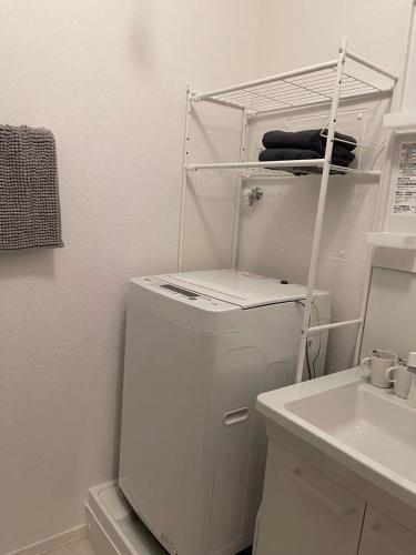 a white refrigerator in a kitchen with a sink at House Nozomi in Kyoto