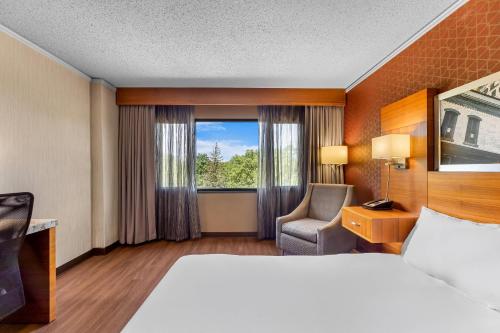 a hotel room with a bed and a chair and a window at Radisson Hotel La Crosse in La Crosse